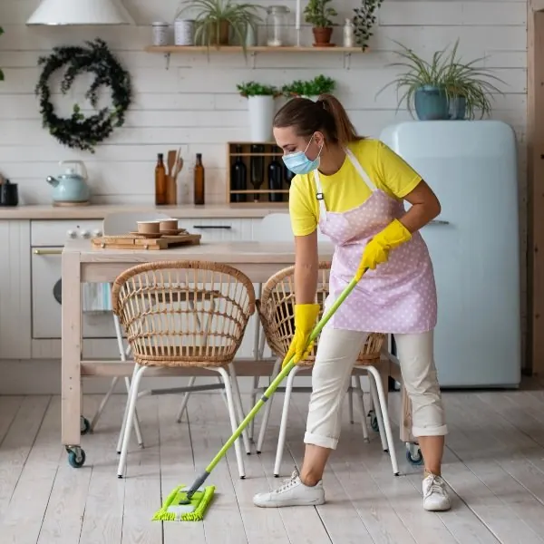 Cleaner wiping a kitchen counter during a house cleaning